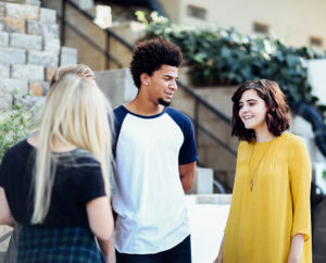 A group of teenagers, smiling in conversation