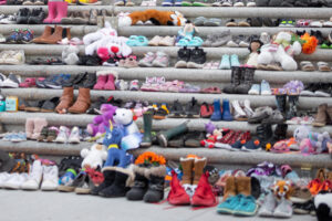 Children's shoes and flowers laid across steps in remembrance of the children who died at Canadian residential schools