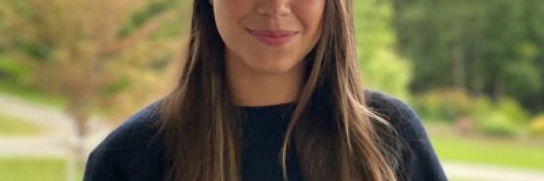 Headshot of young Indigenous woman with long brown.