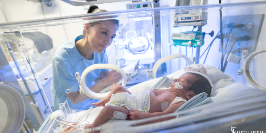 Baby in intensive care with woman watching her baby