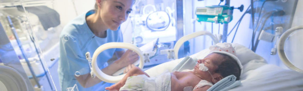 Baby in intensive care with woman watching her baby