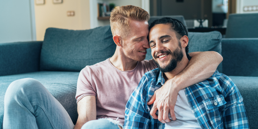 Pictures (12) Two men cuddling by the couch together.