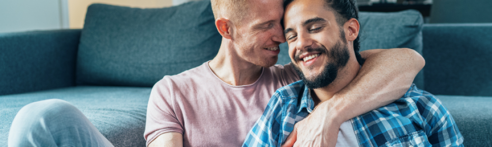 Pictures (12) Two men cuddling by the couch together.